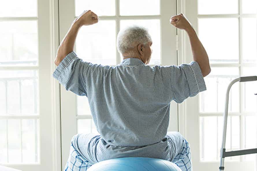 Elderly man on an exercise ball as part of his cancer treatment program